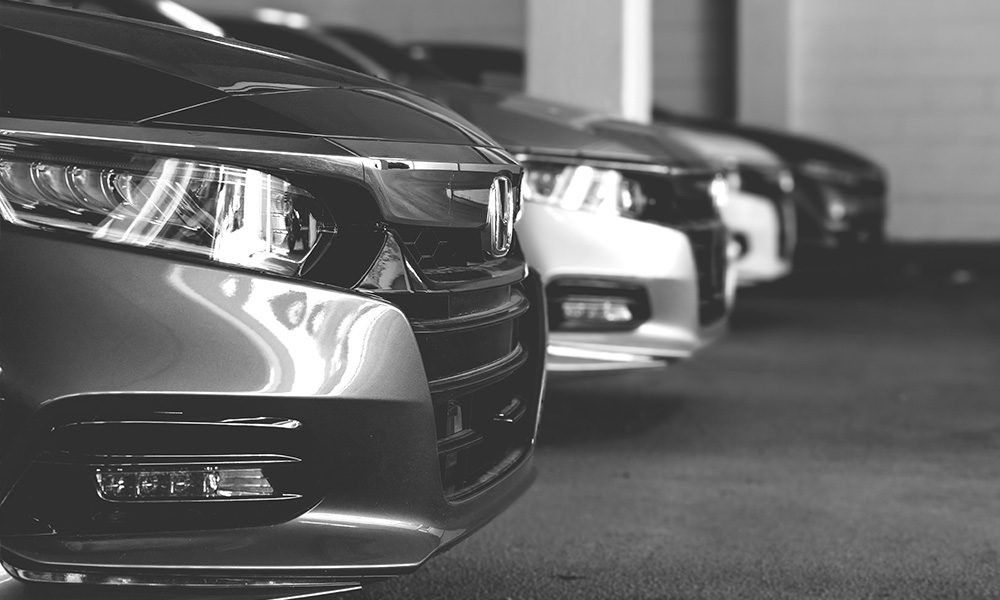 Blog - Grayscale Image of a Line of Shiny Cars in an Indoor Parking Garage