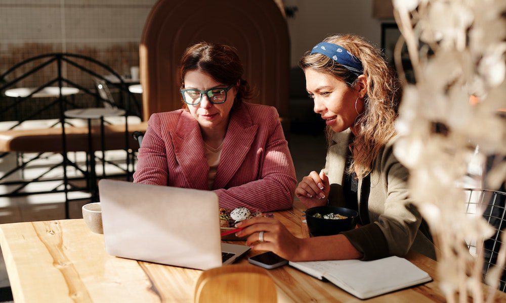 Establishing Workplace Policies on Artificial Intelligence - Two Women Working On A Laptop At Lunch